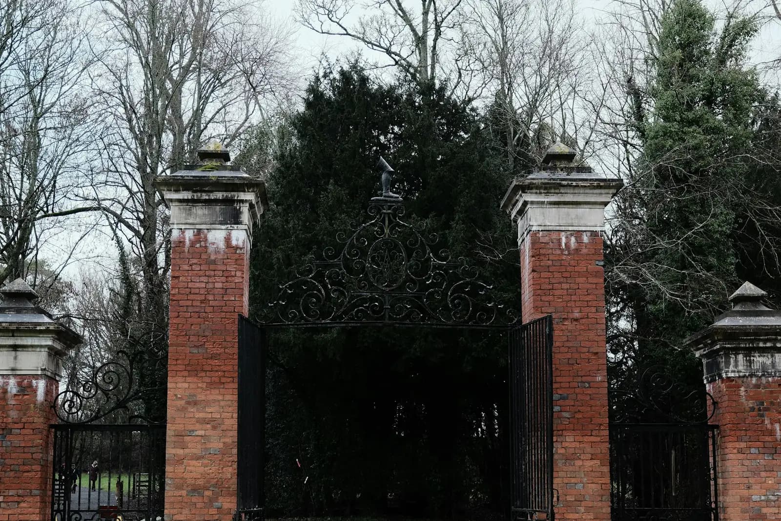 Wrought iron driveway gates between red brick pillars
